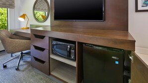 A modern room with a built-in desk, a flat-screen TV, a microwave, and a refrigerator. - Hampton Inn Columbus/Delaware I-71 North (Sunbury)