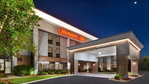 A Hampton Inn hotel entrance with a clear sign, a well-lit welcome area, and a landscaped driveway. - Hampton Inn Columbus/Delaware I-71 North (Sunbury)