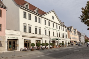 A historic building with a café and a shop on the ground floor, featuring a classic European architectural style. - Best Western Premier Grand Hotel Russischer Hof (Weimar)
