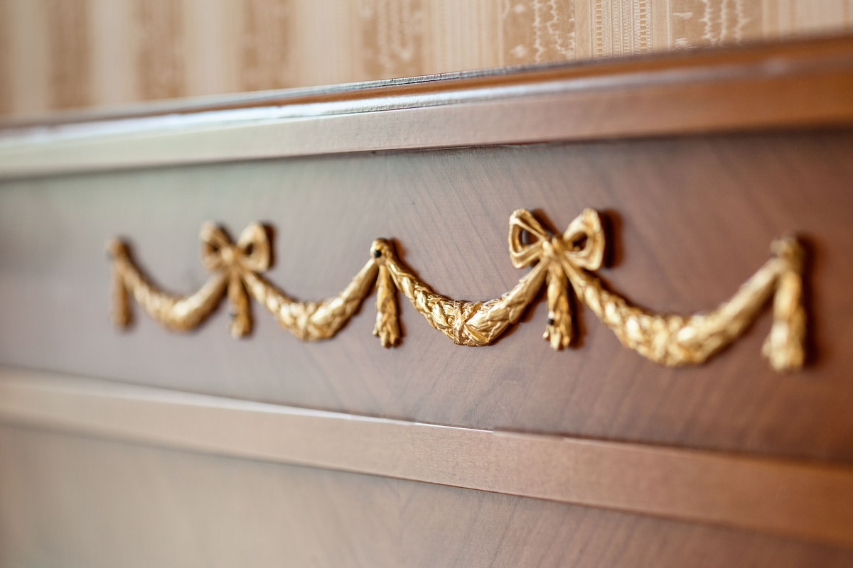 A close-up of a wooden cabinet with a gold rope and bow design.