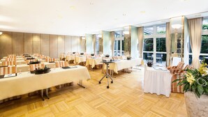 A conference room with multiple tables, chairs, and a large window providing a view of the outdoors. - Best Western Premier Grand Hotel Russischer Hof (Weimar)