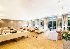 A conference room with multiple tables, chairs, and a large window providing a view of the outdoors. - Best Western Premier Grand Hotel Russischer Hof (Weimar)