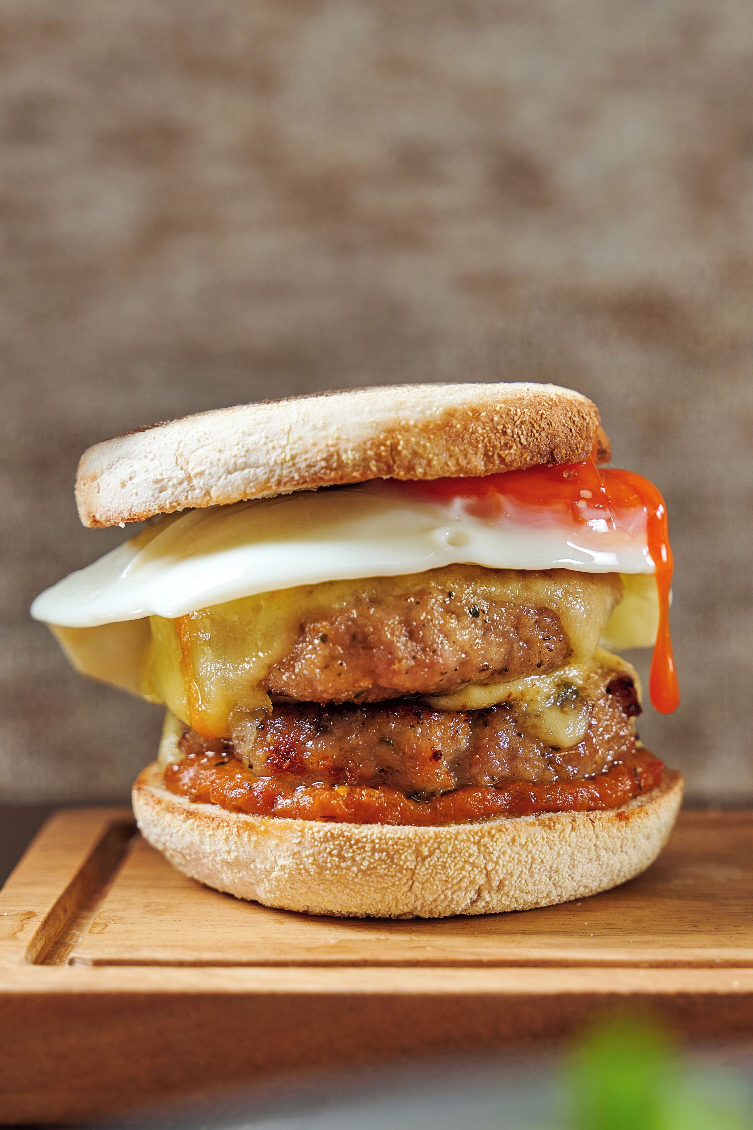 A sandwich with various ingredients on a wooden board.
