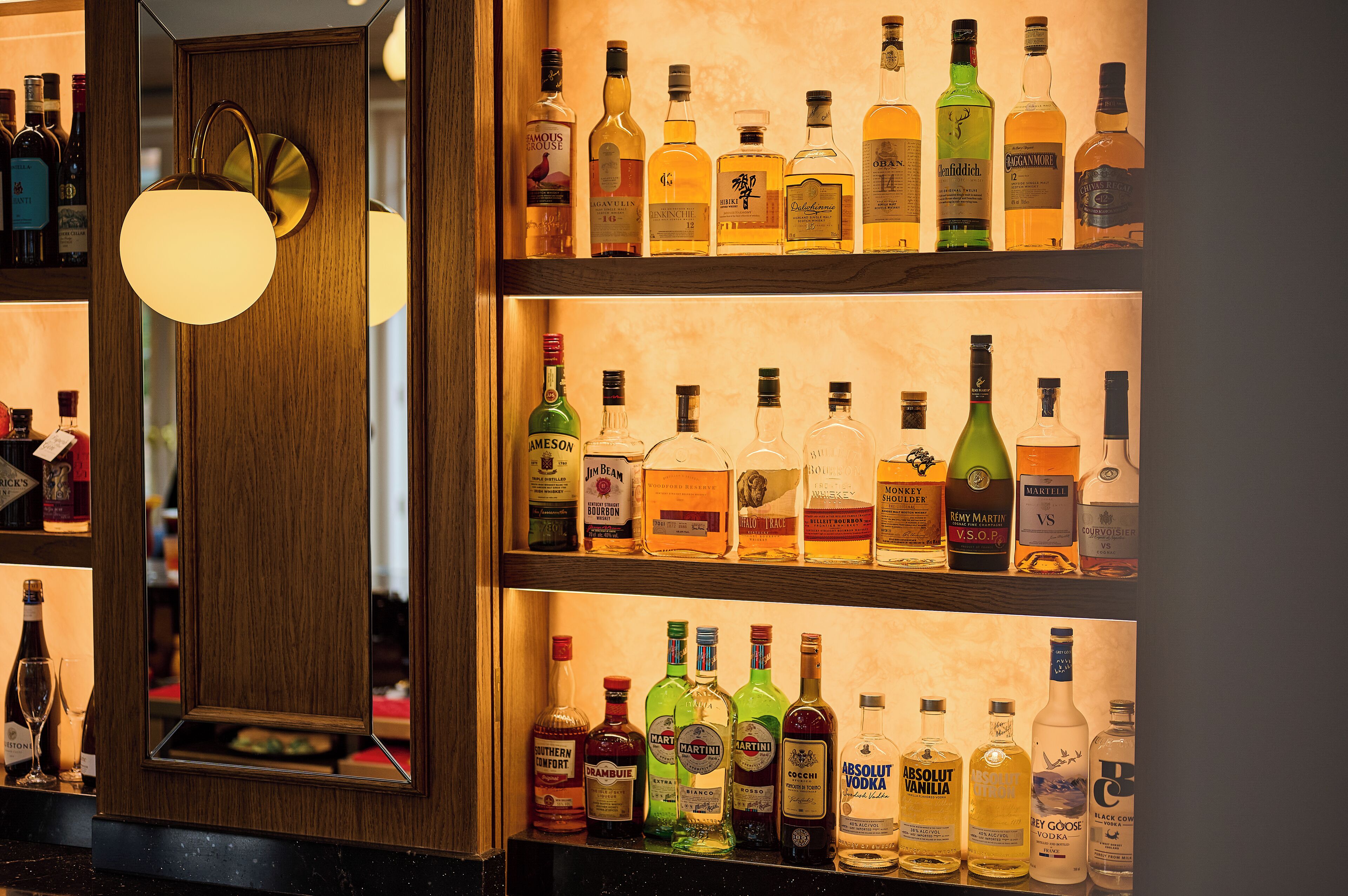 A bar with multiple shelves of liquor bottles.
