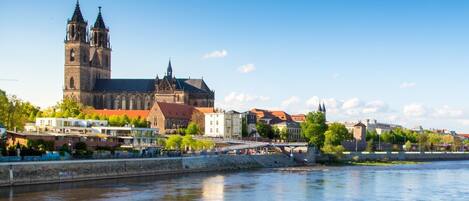 A historic church with twin towers and a river in the foreground.