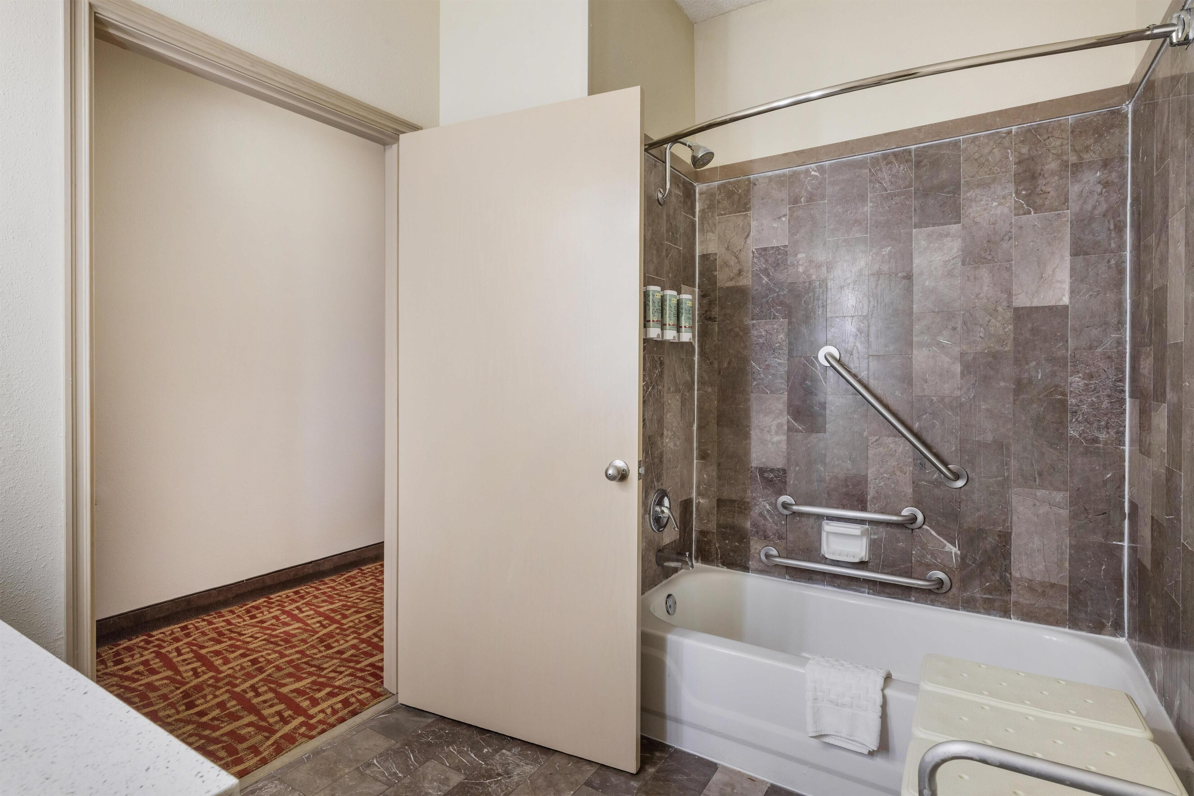 A bathroom with a shower, a bathtub, and a toilet.