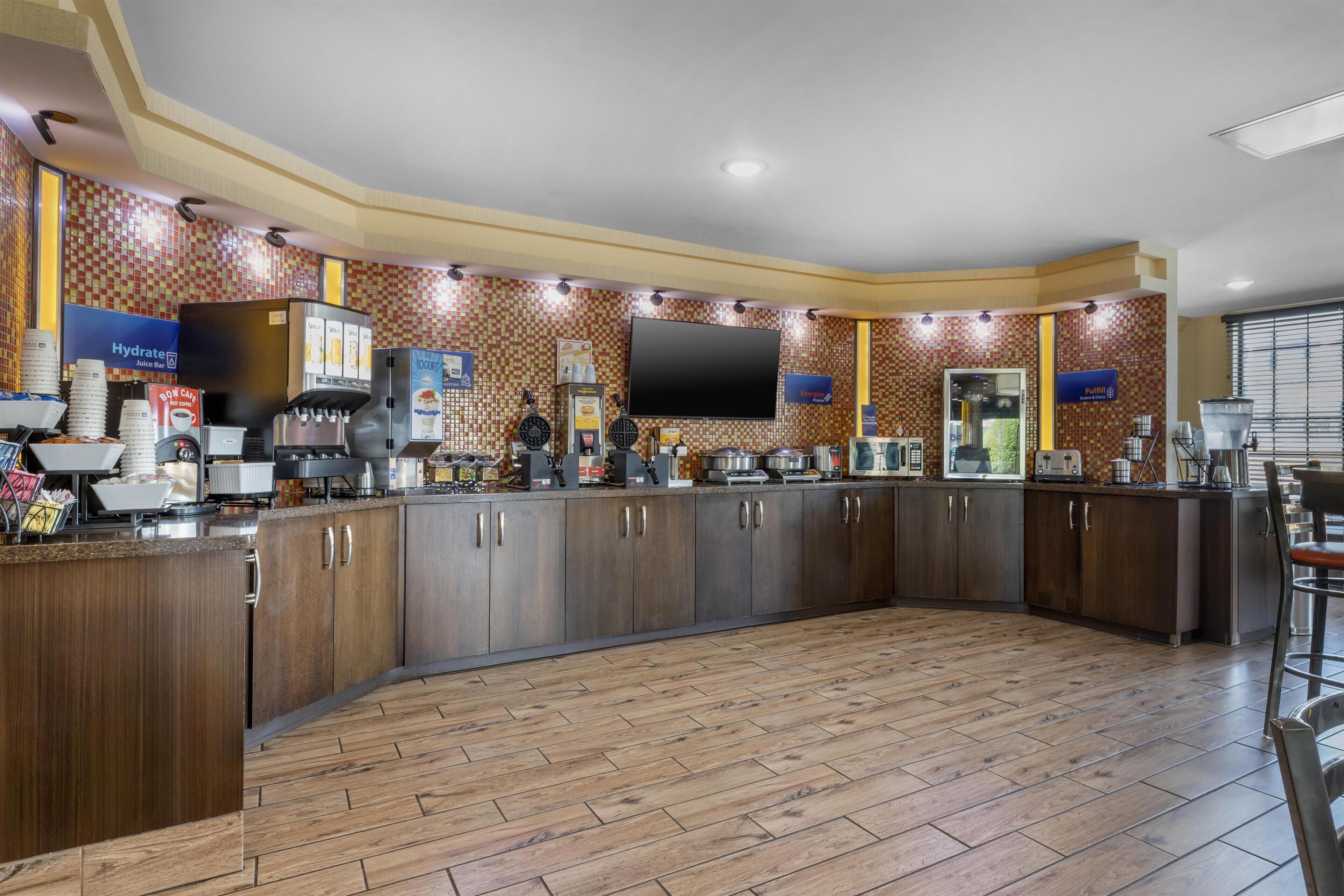 A modern kitchen with a large island, built-in appliances, and a flat-screen TV.