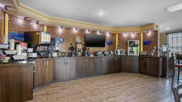Una cocina moderna con una isla grande, electrodomésticos integrados y un televisor de pantalla plana.