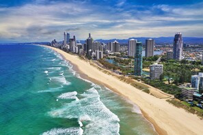 A coastal cityscape with a long sandy beach and high-rise buildings. - Chidori Court (Main Beach)