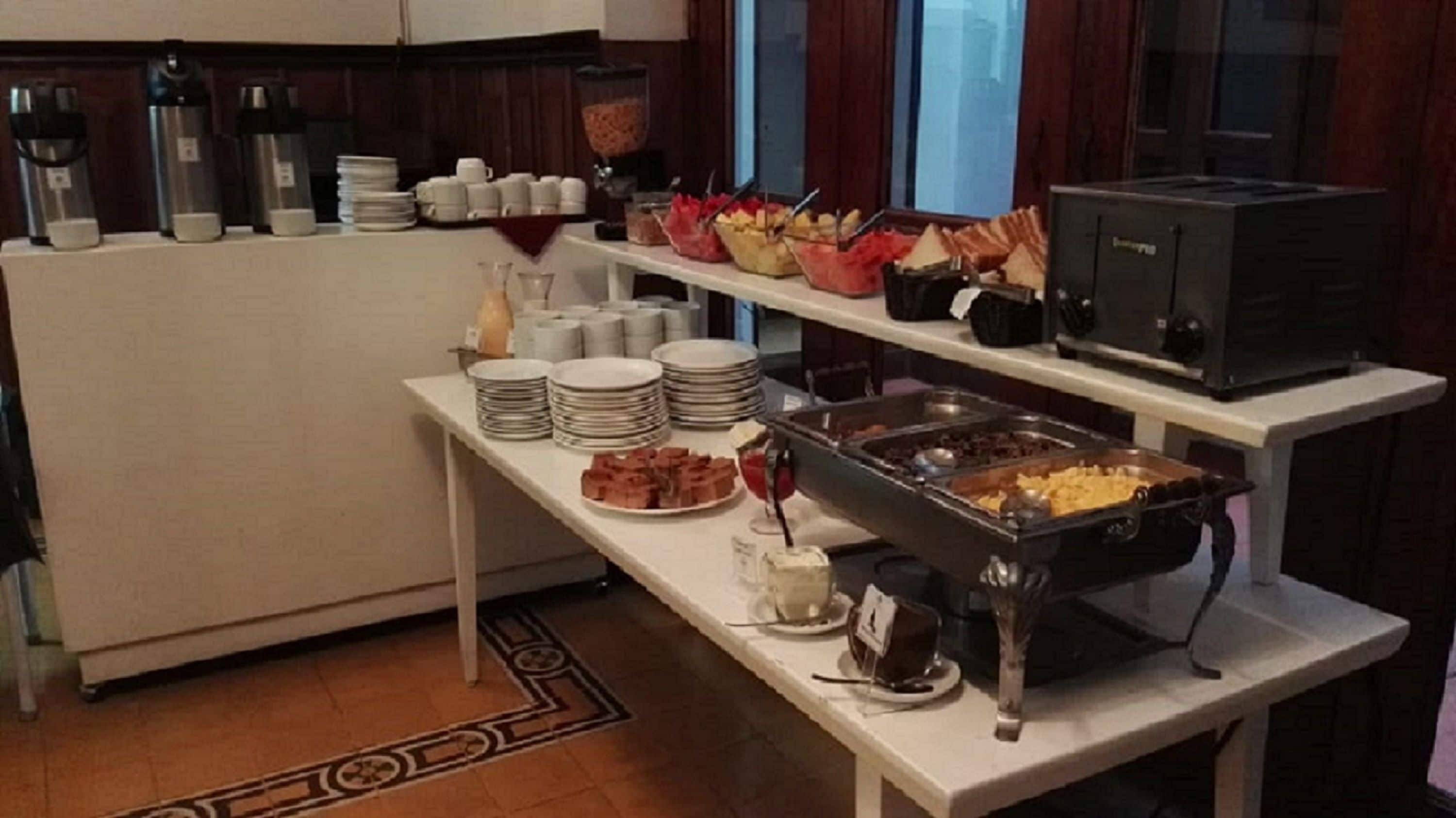 Montaje de bufé con diversos alimentos y condimentos, incluyendo una estación de café y un microondas.