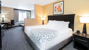 A hotel room with a large bed, a desk with a chair, a lamp, and a picture on the wall. - La Quinta Inn & Suites by Wyndham Logan (Logan)
