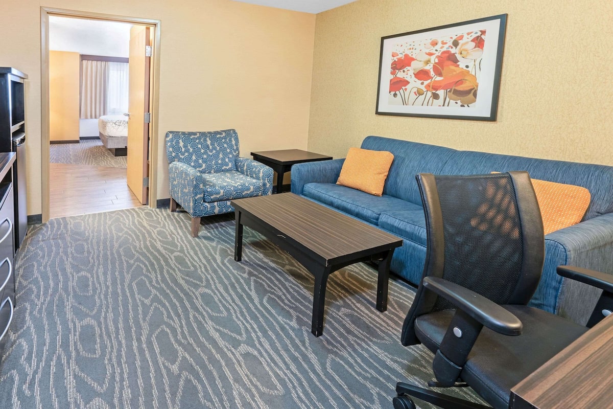 Ein Hotelzimmer mit Sofa, Sesseln, Couchtisch und Fernseher.