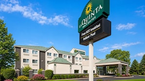 A hotel sign with 'La Quinta Inn & Suites' branding, indicating a hotel with a signboard, a building with a green roof, and a well-maintained lawn. - La Quinta Inn & Suites by Wyndham Logan (Logan)