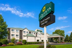 A hotel sign with 'La Quinta Inn & Suites' branding, indicating a hotel with a signboard, a building with a green roof, and a well-maintained lawn. - La Quinta Inn & Suites by Wyndham Logan (Logan)