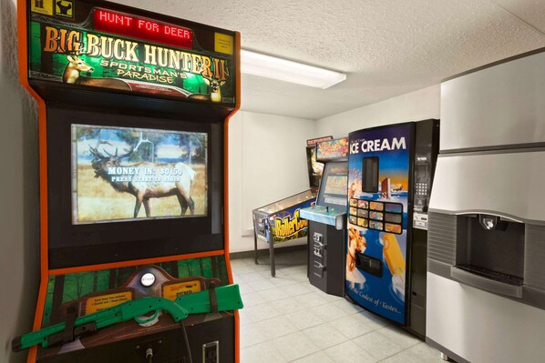 A gaming area with a deer hunting game, a pinball machine, and an ice cream vending machine.