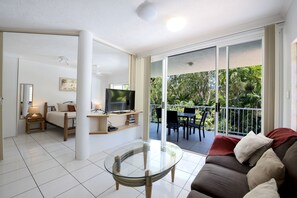 One-Bedroom King Apartment - Pool/Garden View | Coin séjour | TV connectée de 40 pouces avec chaînes numériques, télévision, livres