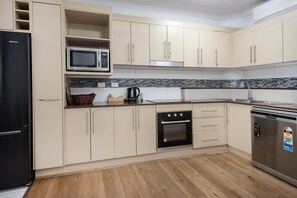 One-Bedroom King Apartment - Pool/Garden View | Cocina privada | Frigorífico grande, microondas, placa de cocina y cafetera o tetera