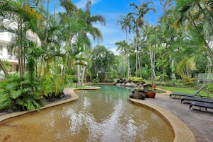 Una piscina al aire libre, sillones reclinables de piscina