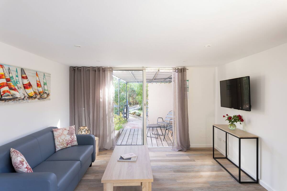 Un salon moderne avec un canapé, une table basse et un téléviseur fixé au mur.