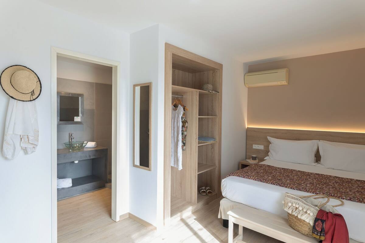 Une chambre à coucher avec un lit, une table de chevet et une armoire en bois.