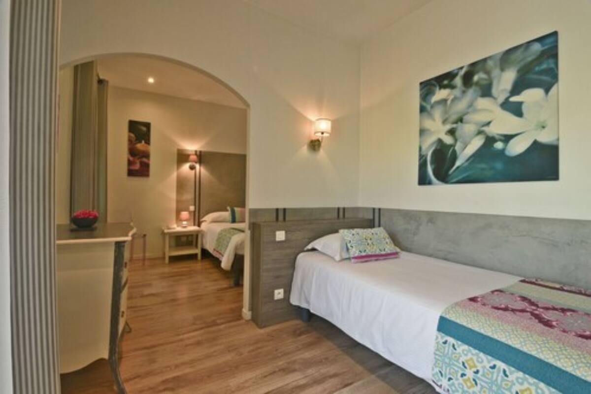 Une chambre à coucher avec un lit, une table de chevet, une lampe et un tableau au mur.