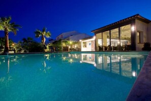 Una piscina al aire libre de temporada, tumbonas