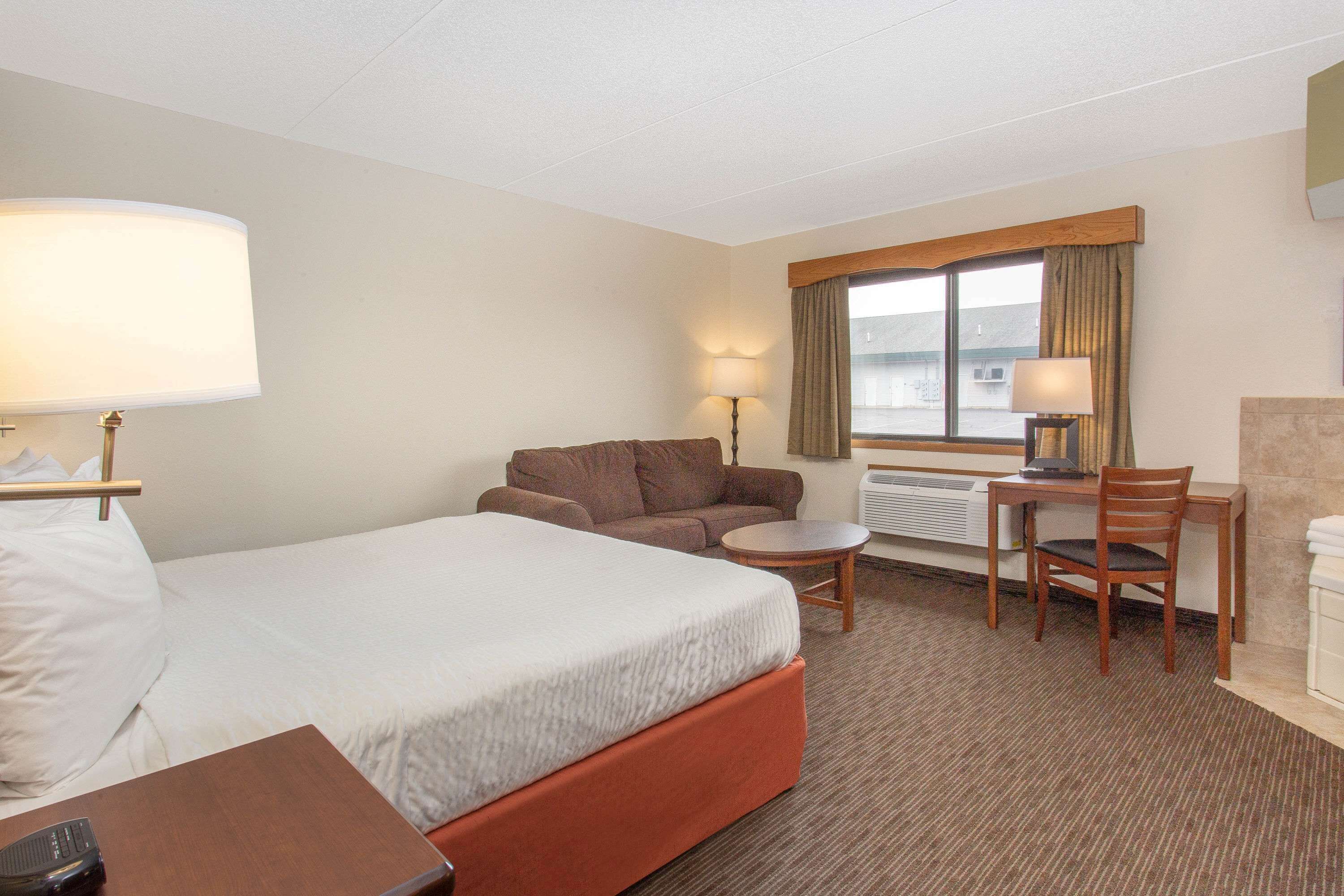 Une chambre d’hôtel avec un lit, un canapé, un bureau et une chaise.