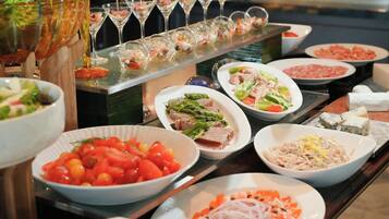 A buffet with various dishes and a selection of glasses.