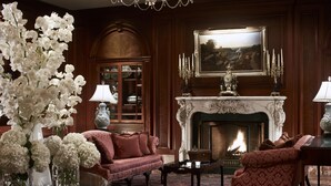 A traditional room with a fireplace, sofas, and a large vase of white flowers. - The Ritz-Carlton, Osaka (Osaka)