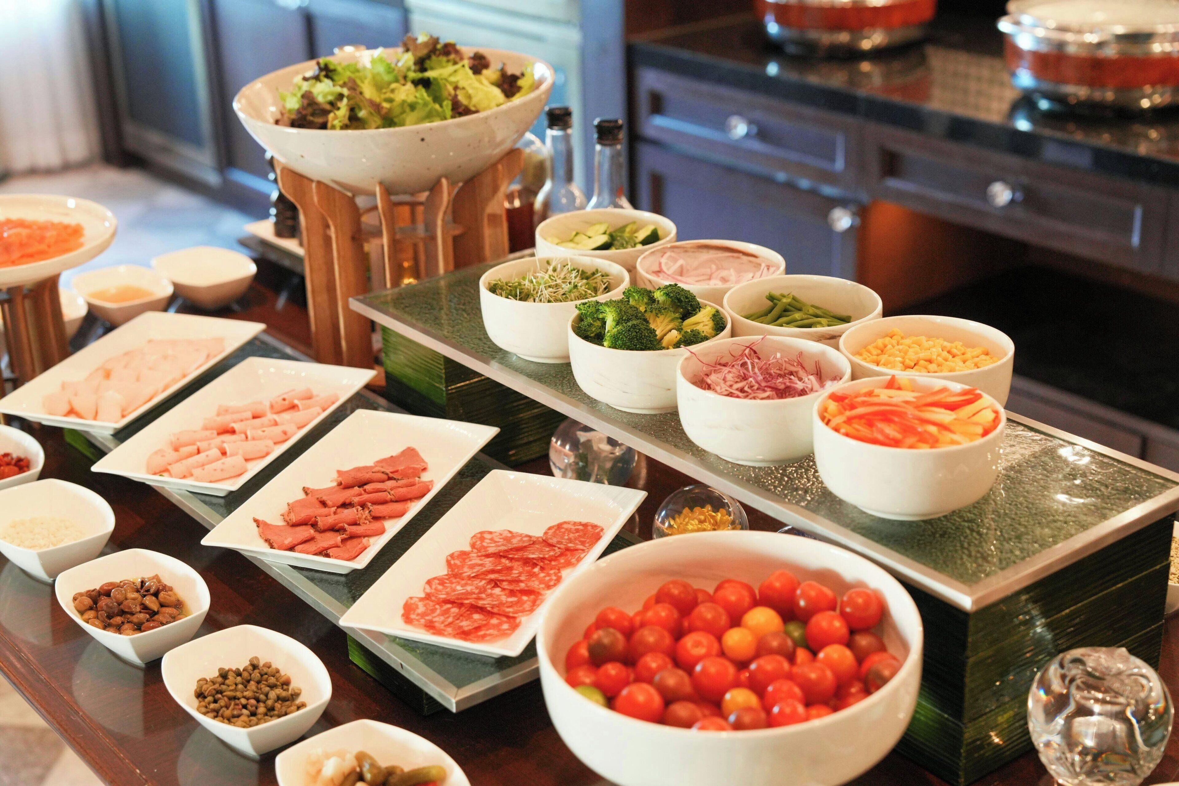 A buffet table with various food items and condiments.