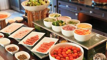 A buffet table with various food items and condiments.