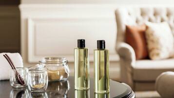 A table with two perfume bottles, a glass jar, and a spoon.