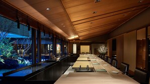 A long conference table with chairs, wooden ceiling, and large windows overlooking a garden. - The Ritz-Carlton, Osaka (Osaka)