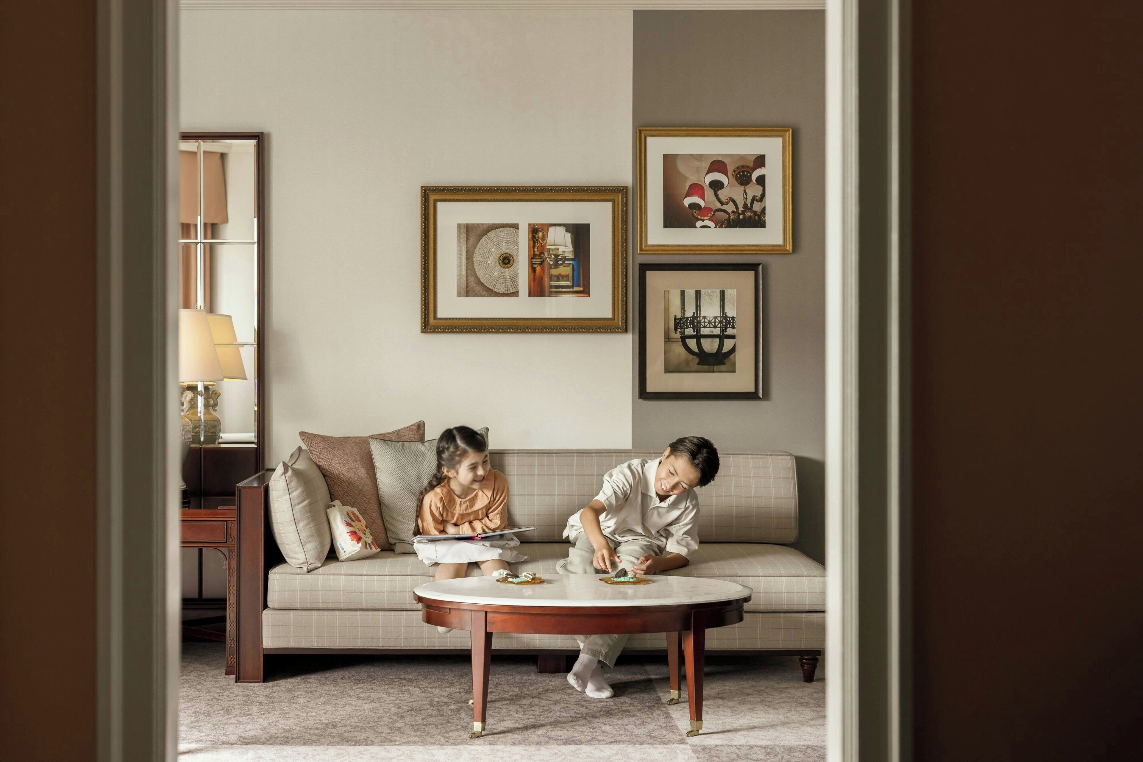 A living room with a sofa, a coffee table, and framed artwork on the wall.