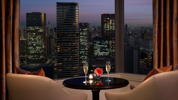 A cityscape view from a high-rise hotel room with a round table and two chairs. - The Ritz-Carlton, Osaka (Osaka)