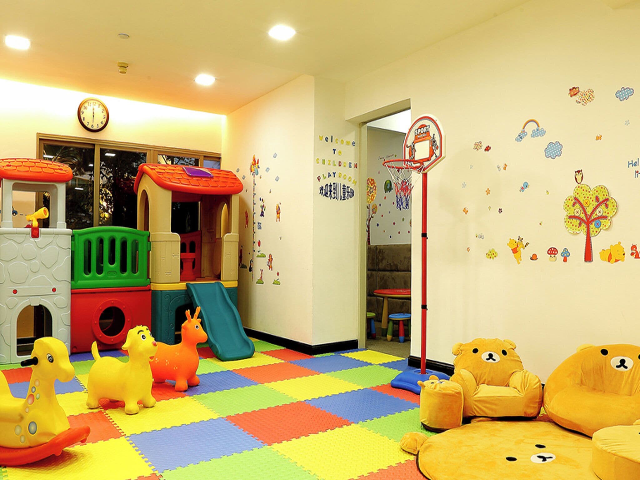 A children's playroom with a playhouse, colorful floor, and wall decorations.
