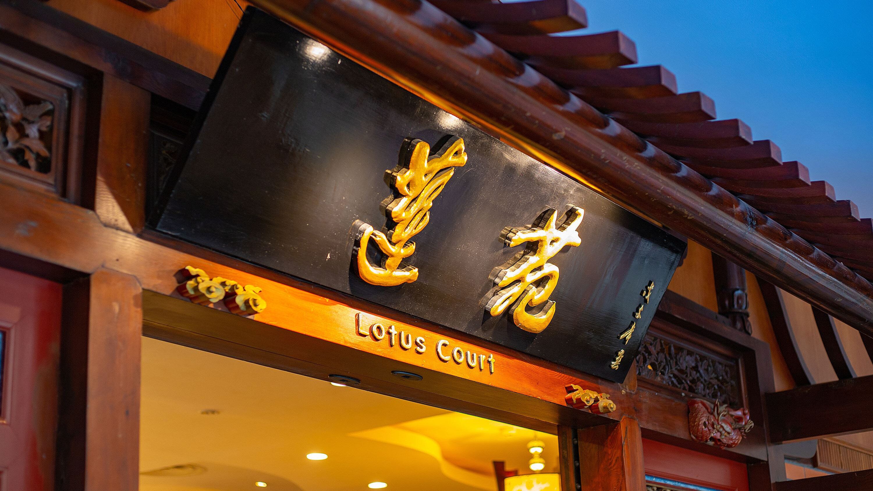 A sign with Chinese characters and the words 'Lotus Court' indicating the name of the establishment.