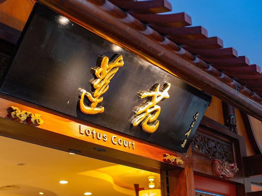 A sign with Chinese characters and the words 'Lotus Court' indicating the name of the establishment.