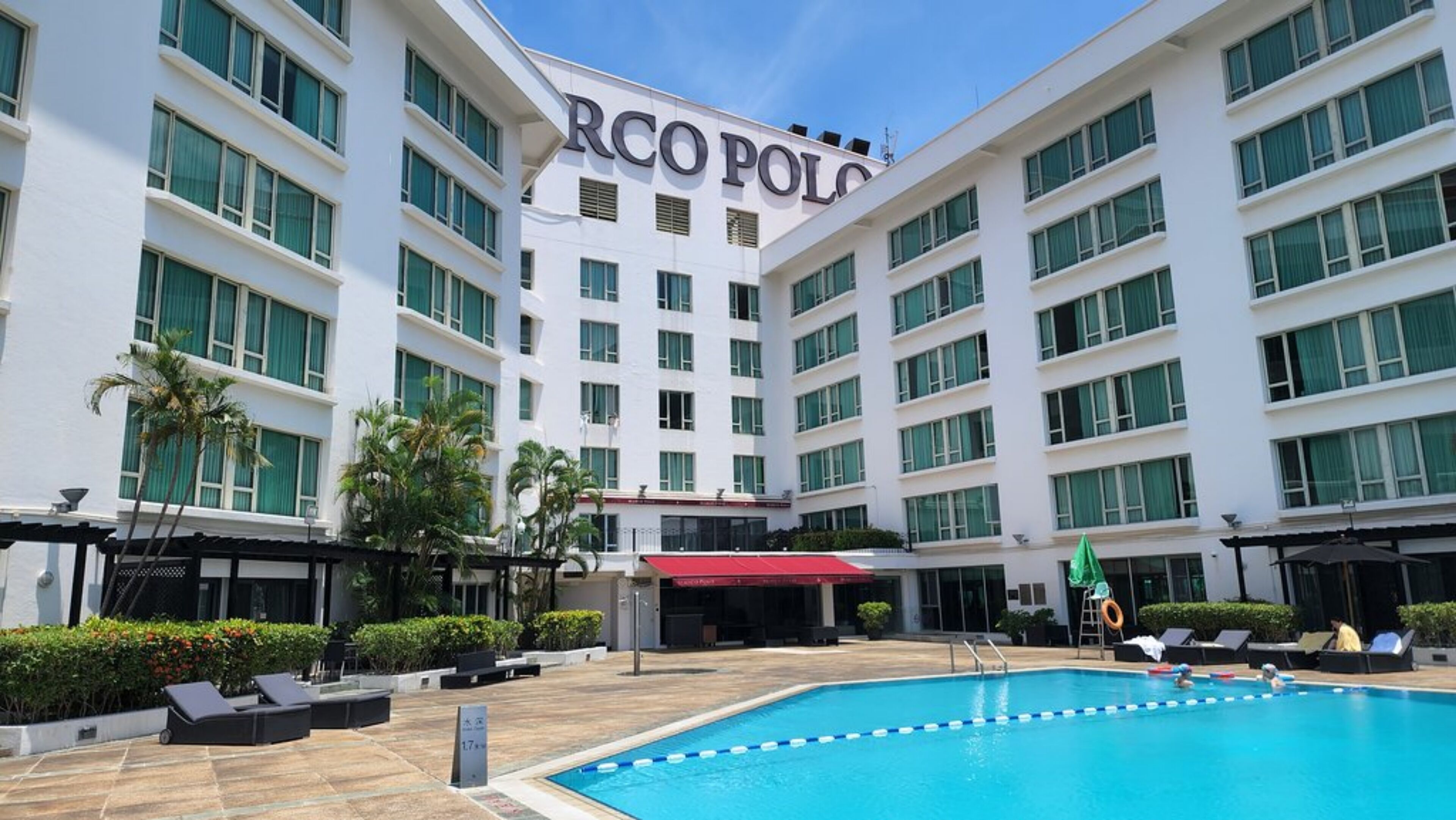 A hotel with a pool area, multiple floors, and a sign reading "RCO POLO".