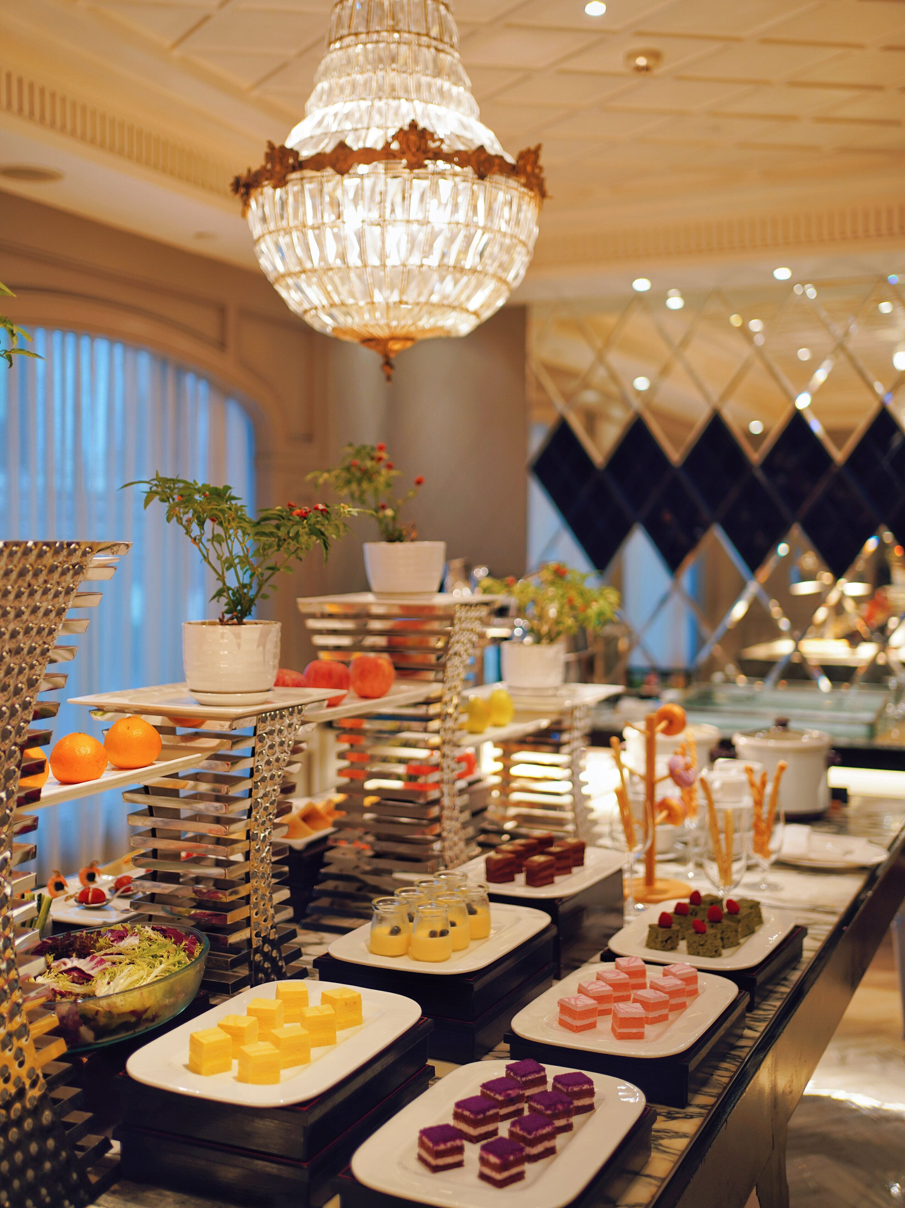 A buffet with various food items and a decorative chandelier.