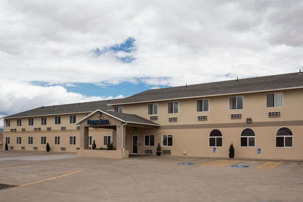 Experience the simplicity of this hotel's flat roof and symmetrical facade, featuring evenly spaced windows and a covered entrance.
