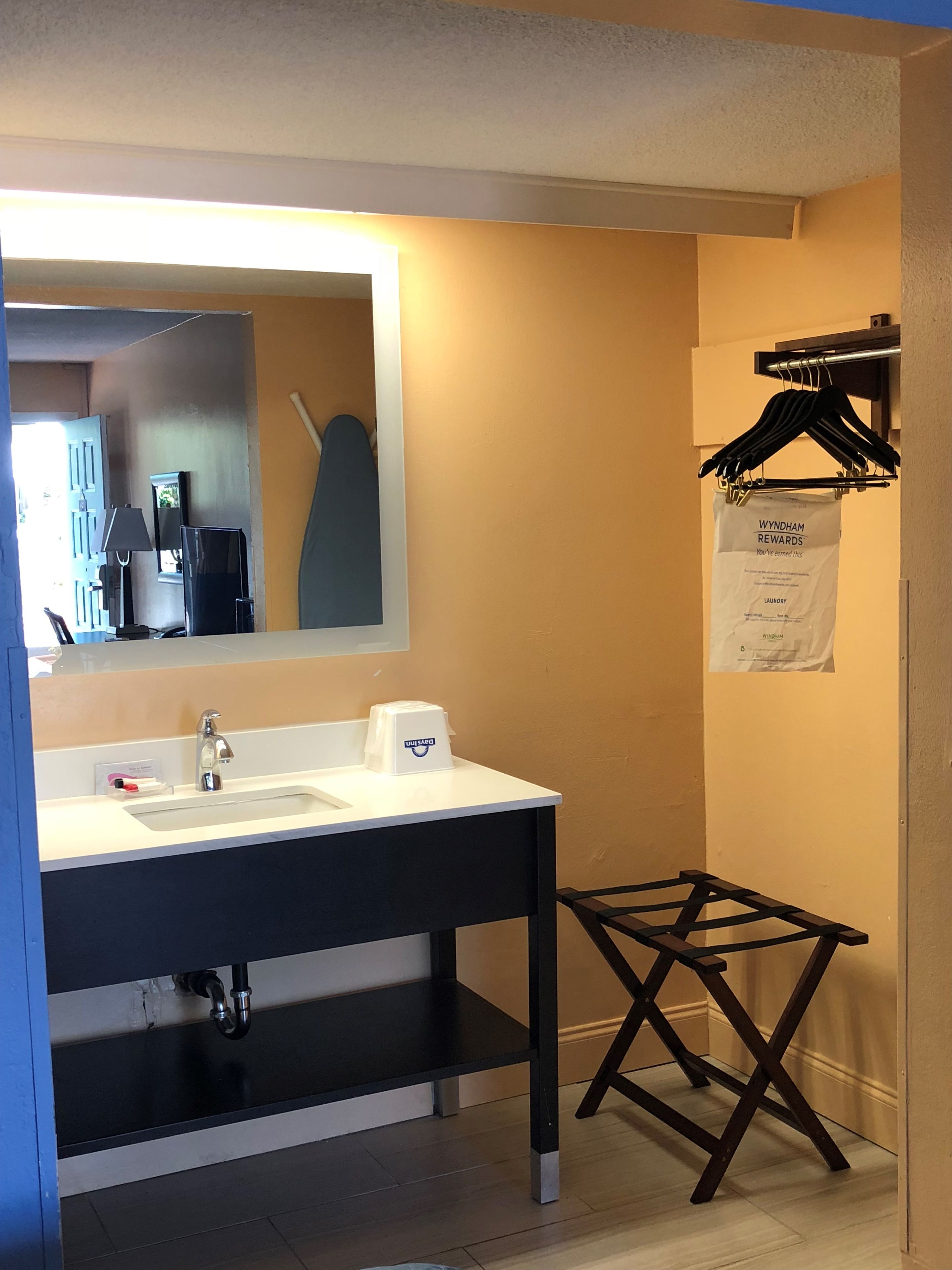 Een badkamer met een wastafel, spiegel en handdoekhouder.