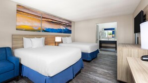 A hotel room with two beds, a desk, a TV, and a painting on the wall. - Days Inn by Wyndham Fort Myers Springs Resort (Fort Myers)