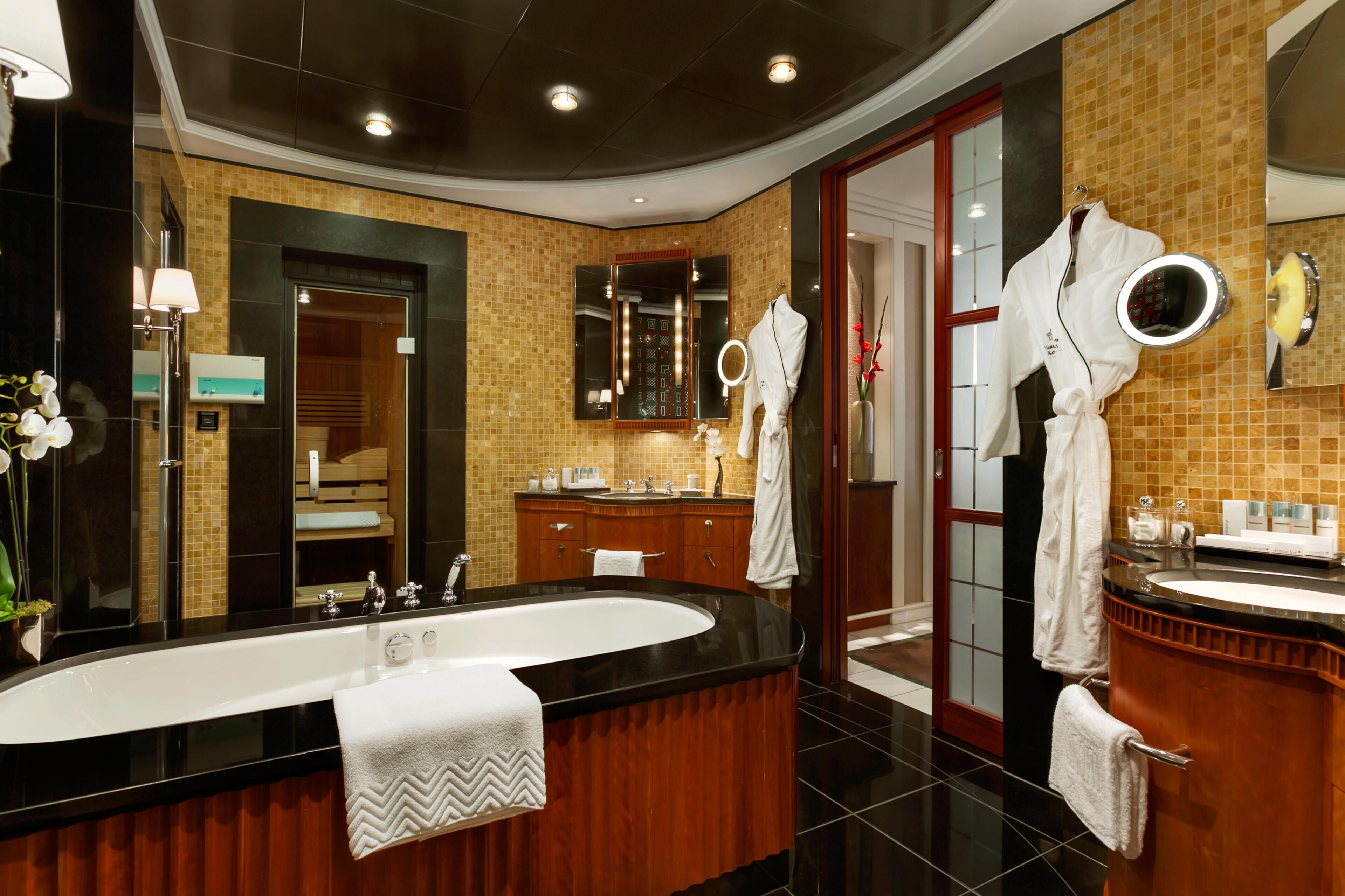 A modern bathroom with a large bathtub, a vanity with a mirror, and a shower area.