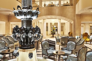 A lobby with a central fountain, seating areas, and a grand staircase. - Hotel Adlon Kempinski (Berlin)