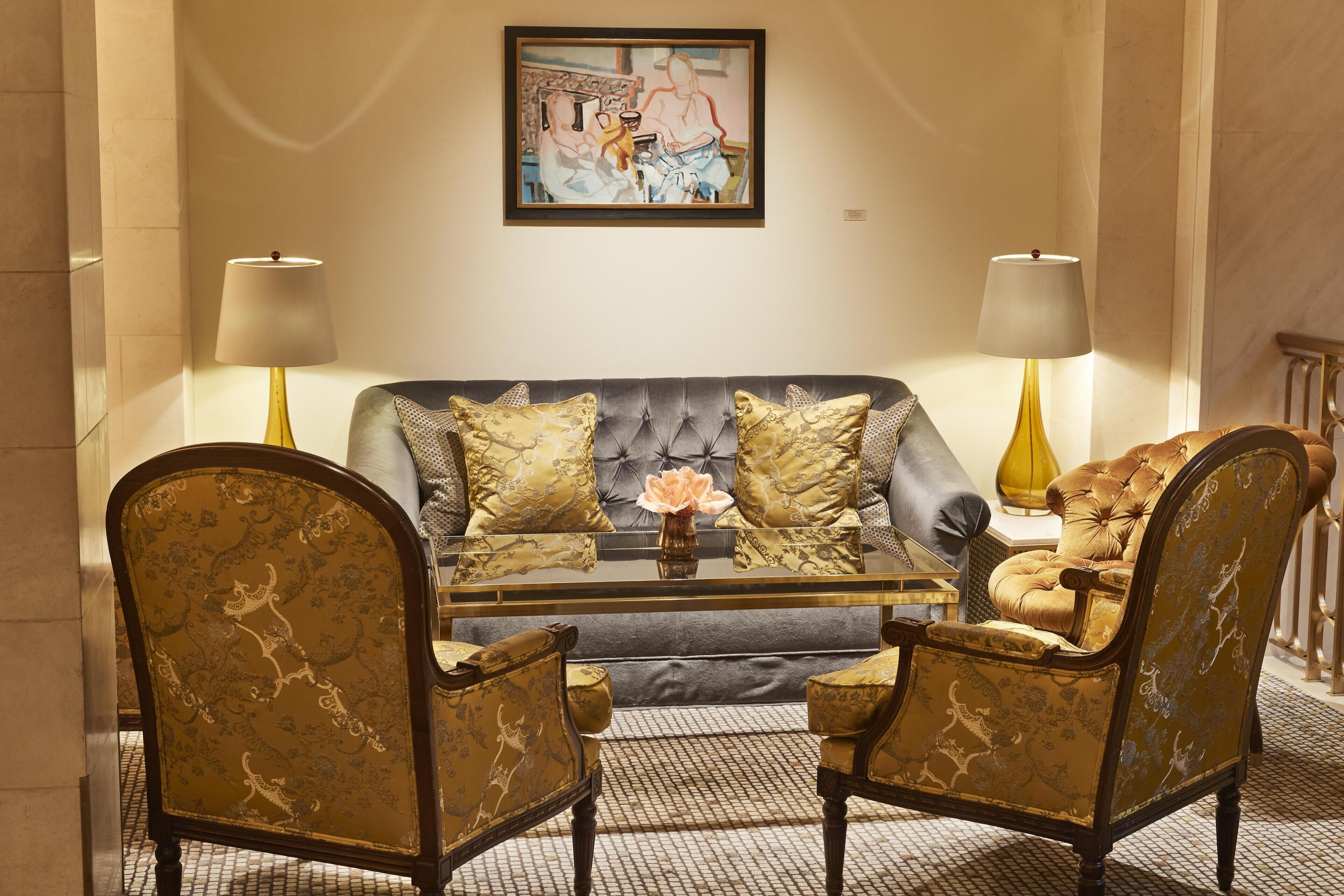Una habitación con un sofá, dos sillones, una mesita de centro y dos lámparas.