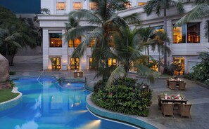 A hotel courtyard with a swimming pool, palm trees, and outdoor seating. - ITC Kakatiya, a Luxury Collection Hotel, Hyderabad (Hyderabad)