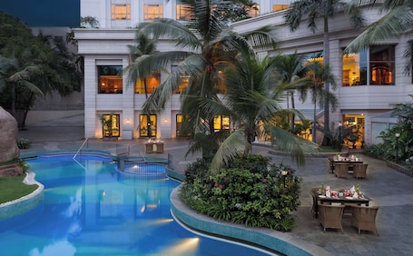 Una piscina al aire libre, sillones reclinables de piscina