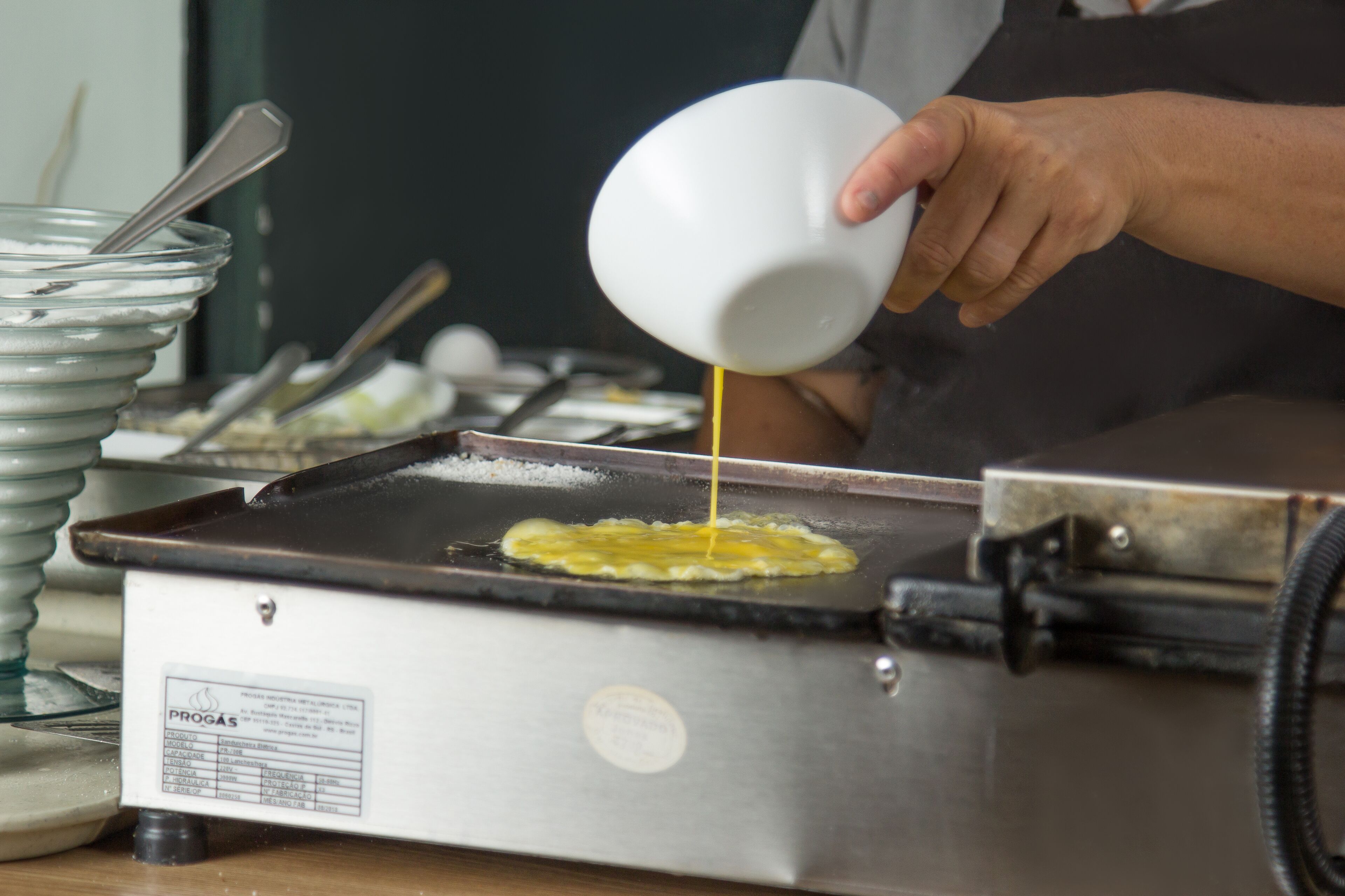 A person pouring batter onto a griddle.