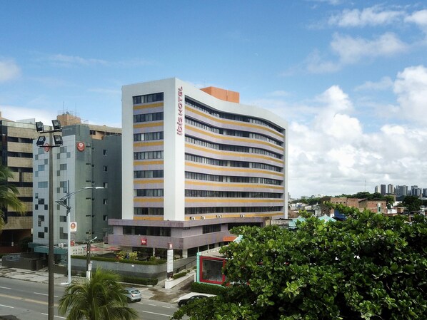 A multi-story hotel with a modern design, featuring a prominent entrance and a rooftop terrace. - Ibis Maceio Pajucara (Maceió)